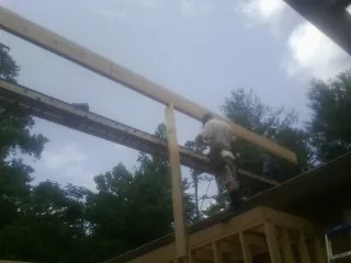 Carpenter setting a ridge beam over a new addition frame — Ice Dam Removal by Roofing Brothers in Minnesota City